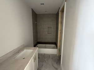 Full bath featuring vanity and light marble finish floors