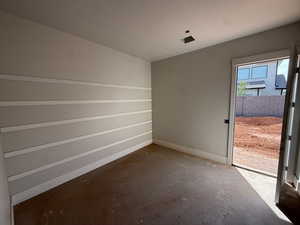 Spare room with baseboards and unfinished concrete floors