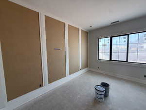 Empty room featuring unfinished concrete flooring and baseboards