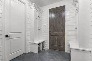 Mudroom featuring wood walls