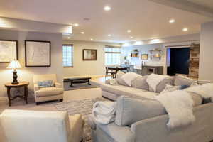 Carpeted living room with a barn door, recessed lighting, and wet bar