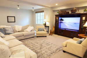 Carpeted living area featuring recessed lighting and baseboards