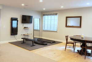 Workout room with light wood-style flooring and recessed lighting