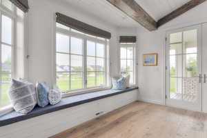 Unfurnished room with a wood ceiling with exposed beams, light wood-type flooring, and french doors