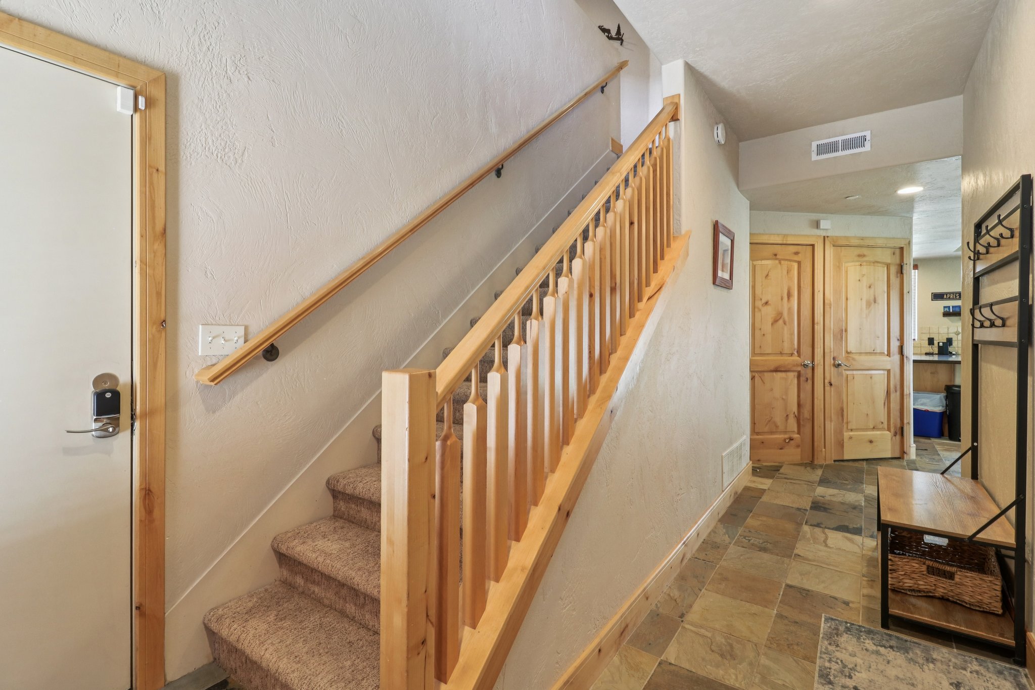 Staircase with stone finish floors and a textured wall