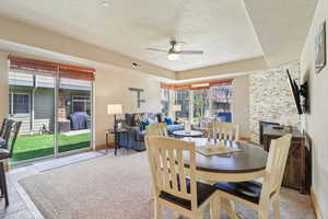 Dining space featuring a ceiling fan and a fireplace