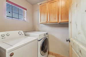 Laundry area featuring cabinet space and separate washer and dryer
