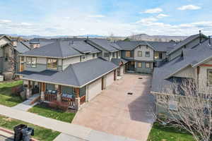 View of front of property with roof with shingles, a mountain view, covered porch, and concrete driveway