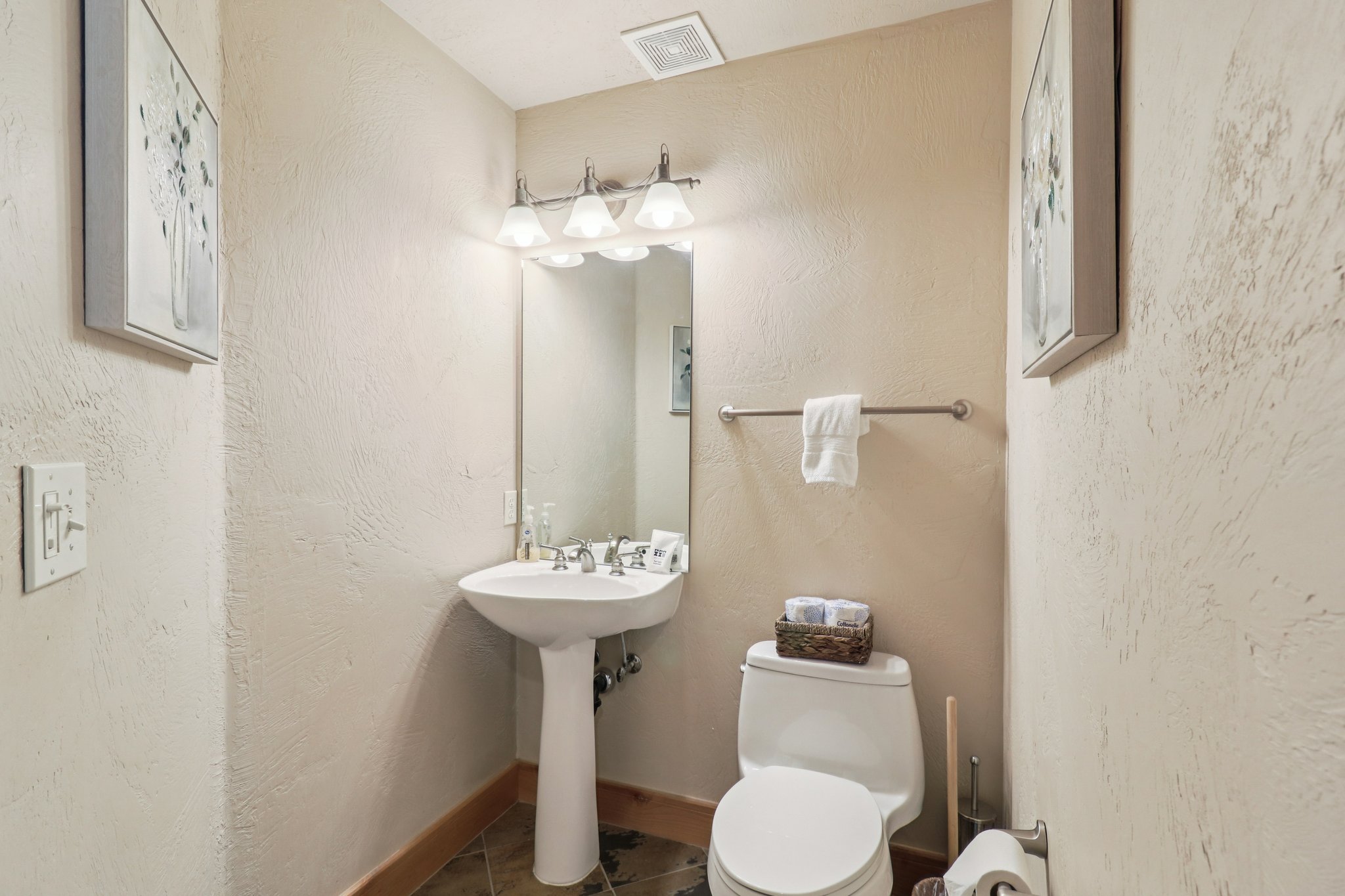 Half bathroom with tile patterned flooring and a textured wall
