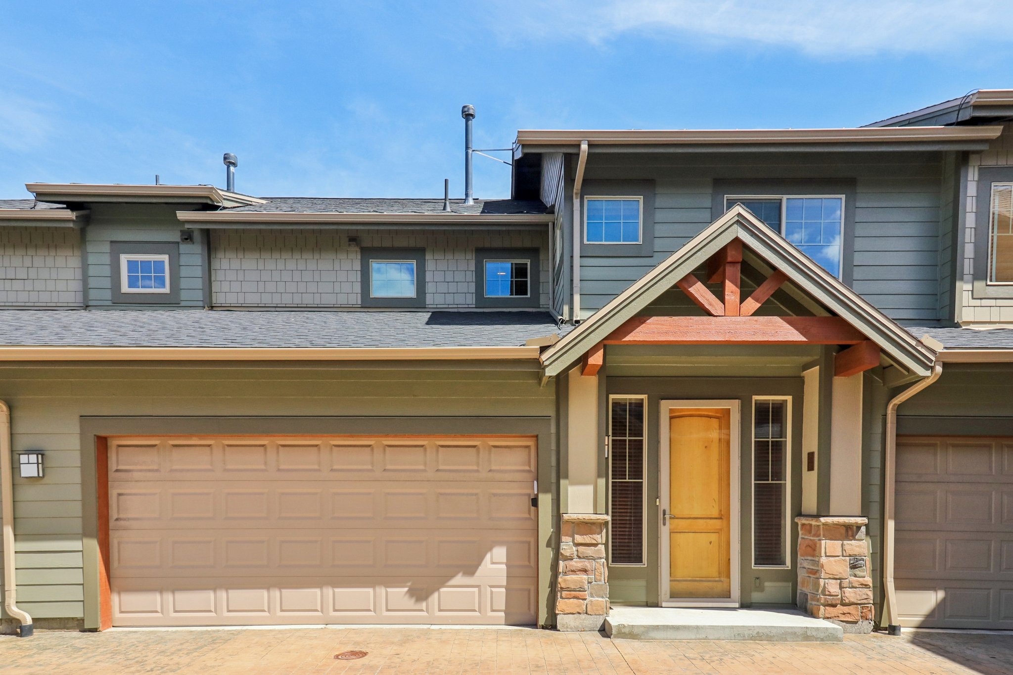 Craftsman house with covered porch, a garage, roof with shingles, and decorative driveway