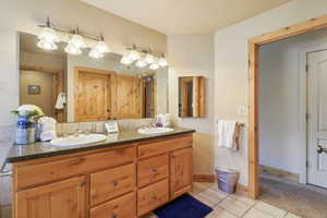 Bathroom featuring double vanity and light tile patterned flooring