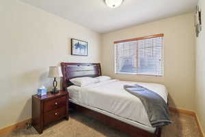Bedroom featuring carpet and a textured wall