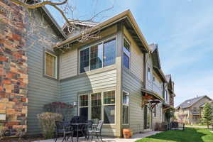 Back of house with a patio and a yard