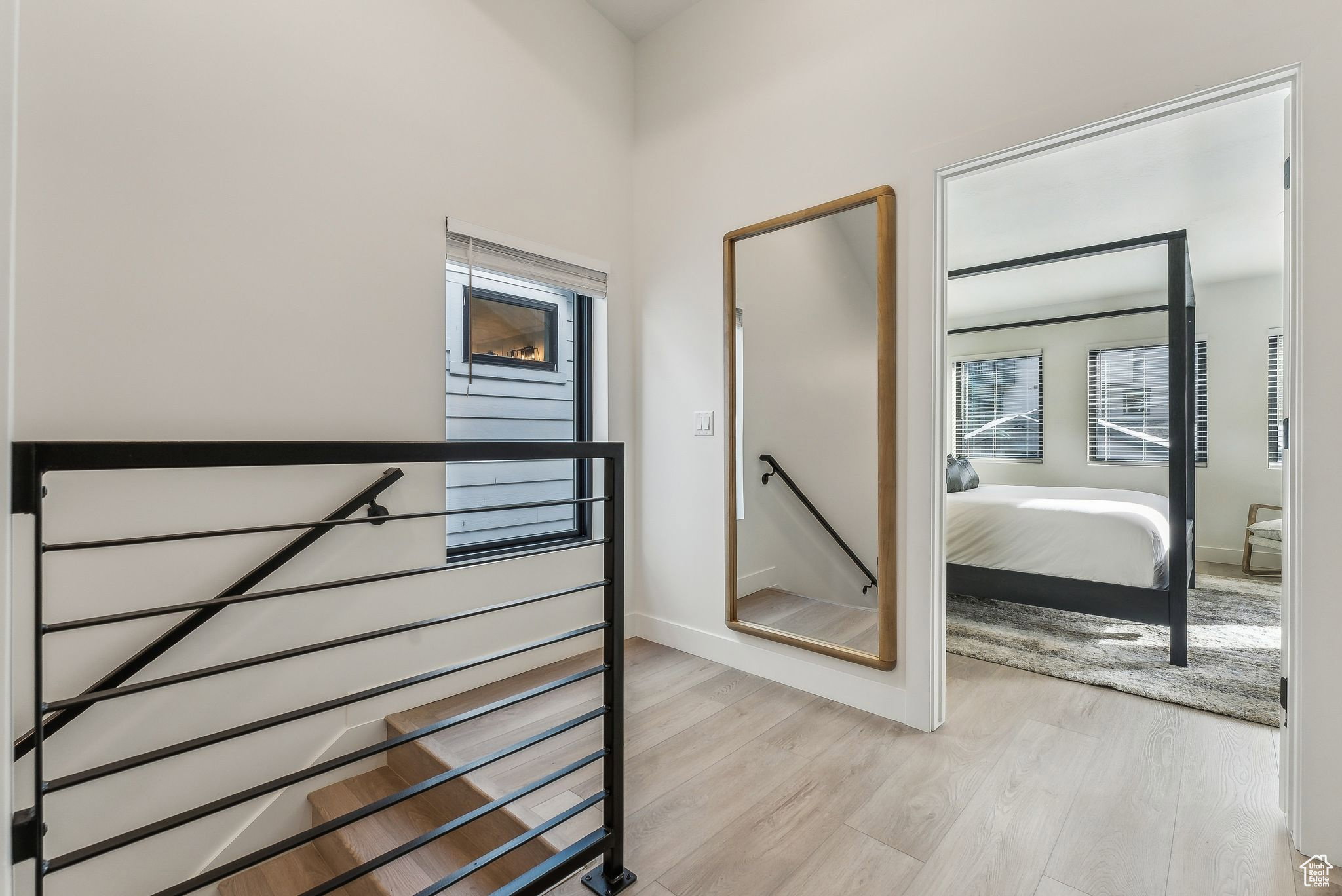 Hall with an upstairs landing and light wood-style floors