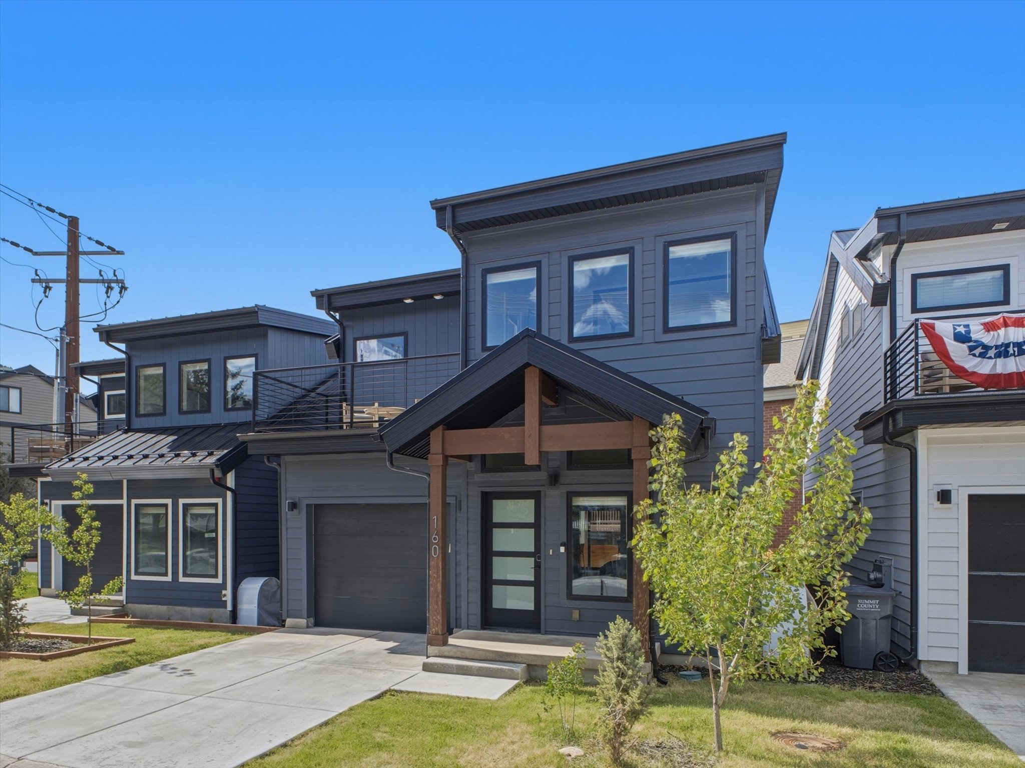 Modern multi-story facade featuring dark grey siding and black-framed windows