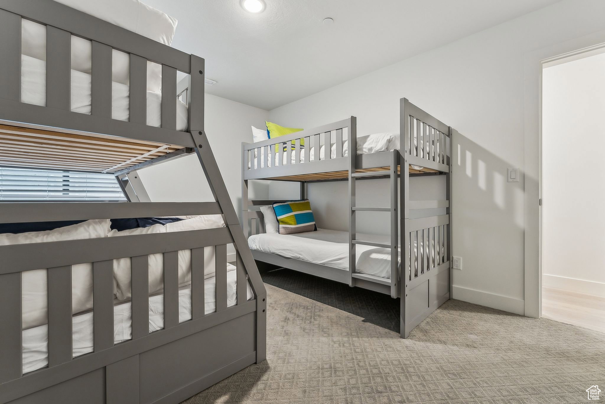 Bedroom featuring light carpet and baseboards