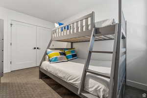 Bedroom featuring dark colored carpet and a closet