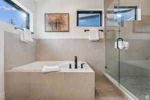 Full bathroom featuring a garden tub, a stall shower, and light wood-style floors