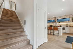 Staircase featuring recessed lighting and wood finished floors
