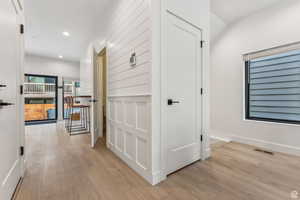 Hallway with light wood-type flooring and recessed lighting