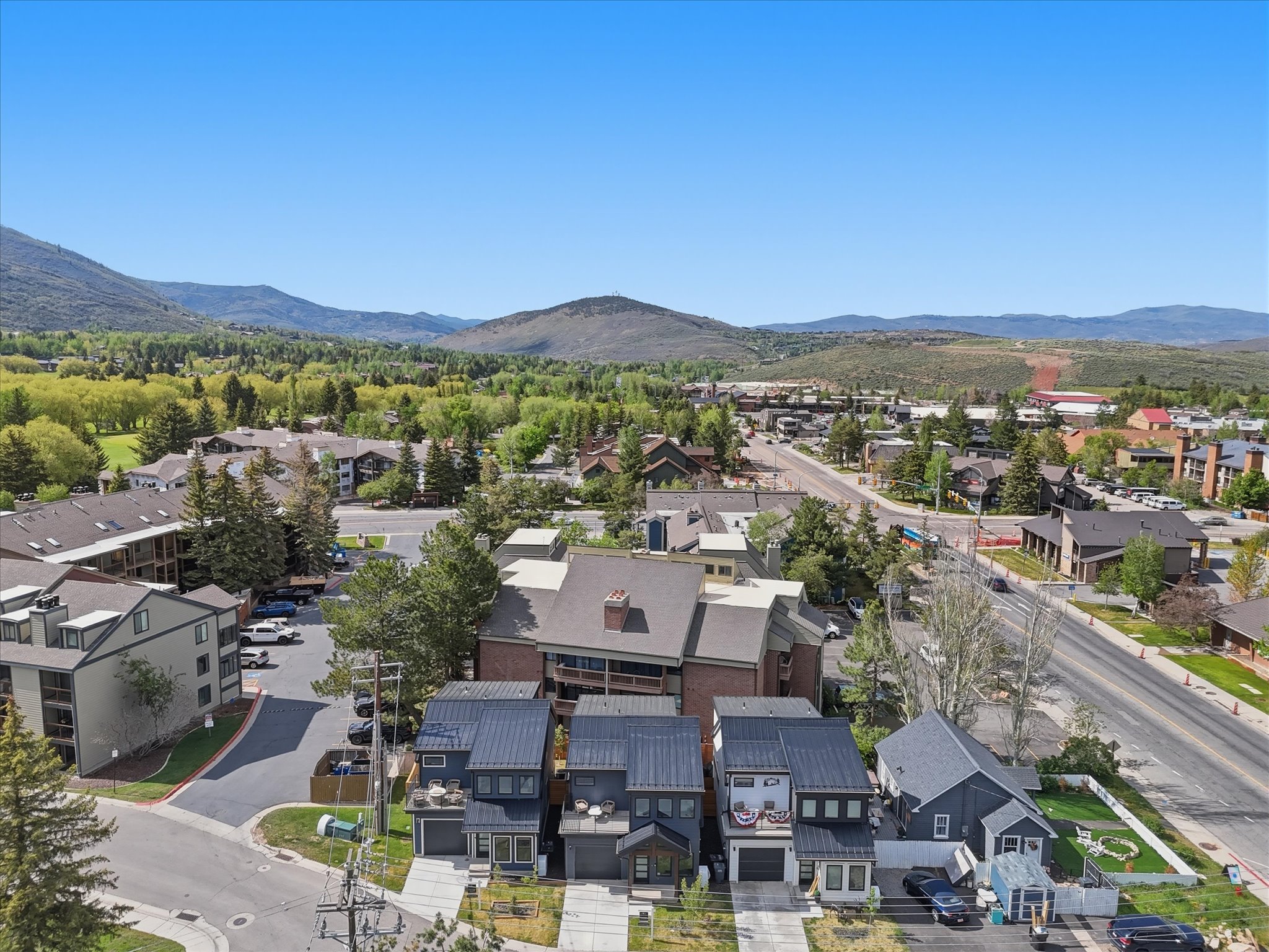 Modern townhomes featuring dark siding, metal roofs, and attached garages