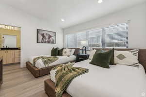 Bedroom featuring lofted ceiling, light wood-style flooring, and recessed lighting