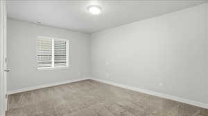 Unfurnished room with baseboards and light carpet