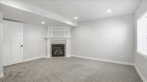 Unfurnished living room with recessed lighting, light carpet, a tile fireplace, and a textured ceiling