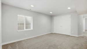 Unfurnished bedroom with light carpet, a closet, and recessed lighting