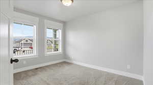 Spare room with light carpet and baseboards