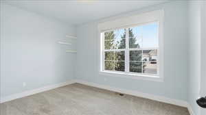 Carpeted spare room with baseboards