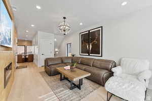 Living room with light wood-type flooring and a chandelier