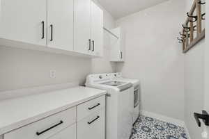 Laundry area with independent washer and dryer, light tile patterned flooring, and cabinet space