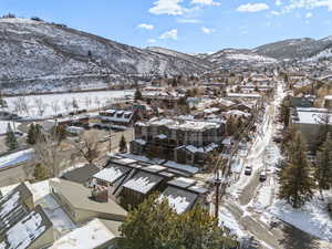 Snowy aerial view featuring a mountain view and a residential view