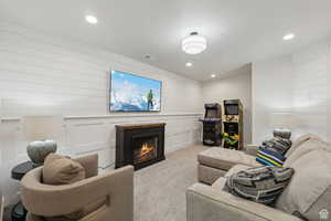Living area featuring a glass covered fireplace, carpet floors, and recessed lighting