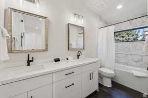 Bathroom with double vanity, shower / tub combo with curtain, and recessed lighting