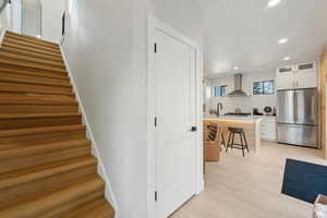Stairs with recessed lighting and wood finished floors