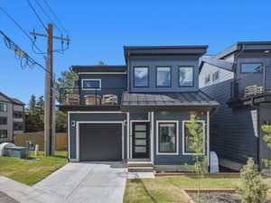 Modern facade featuring dark blue siding and a black metal roof
