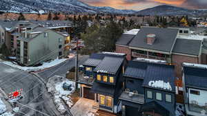Snowy aerial view with a mountain view and a residential view