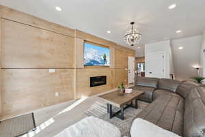 Living area with a glass covered fireplace, hanging lights, and wood finished floors