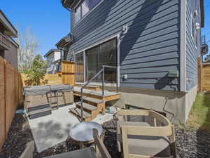 Private patio area featuring a hot tub, concrete paving, and a wooden privacy fence