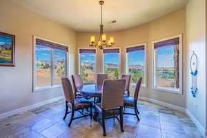 Dining room featuring hanging lights and stone tile flooring