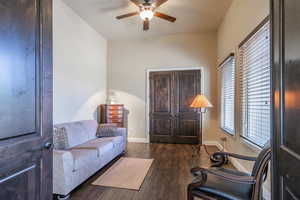 Sitting room with ceiling fan and dark wood finished floors