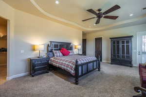 Bedroom featuring carpet flooring, a tray ceiling, ceiling fan, recessed lighting, and a spacious closet