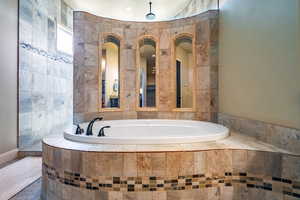 Bathroom featuring a bath and tile walls