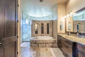 Full bath featuring vanity, a garden tub, and walk in shower