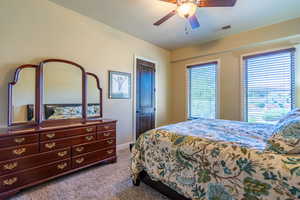 Bedroom featuring dark carpet and a ceiling fan