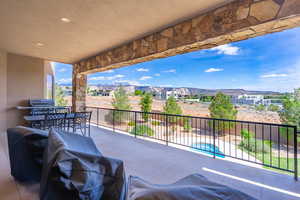 View of patio / terrace with outdoor dining space, grilling area, a residential view, a mountain view, and an in-ground hot tub