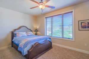 Bedroom with a ceiling fan and carpet floors