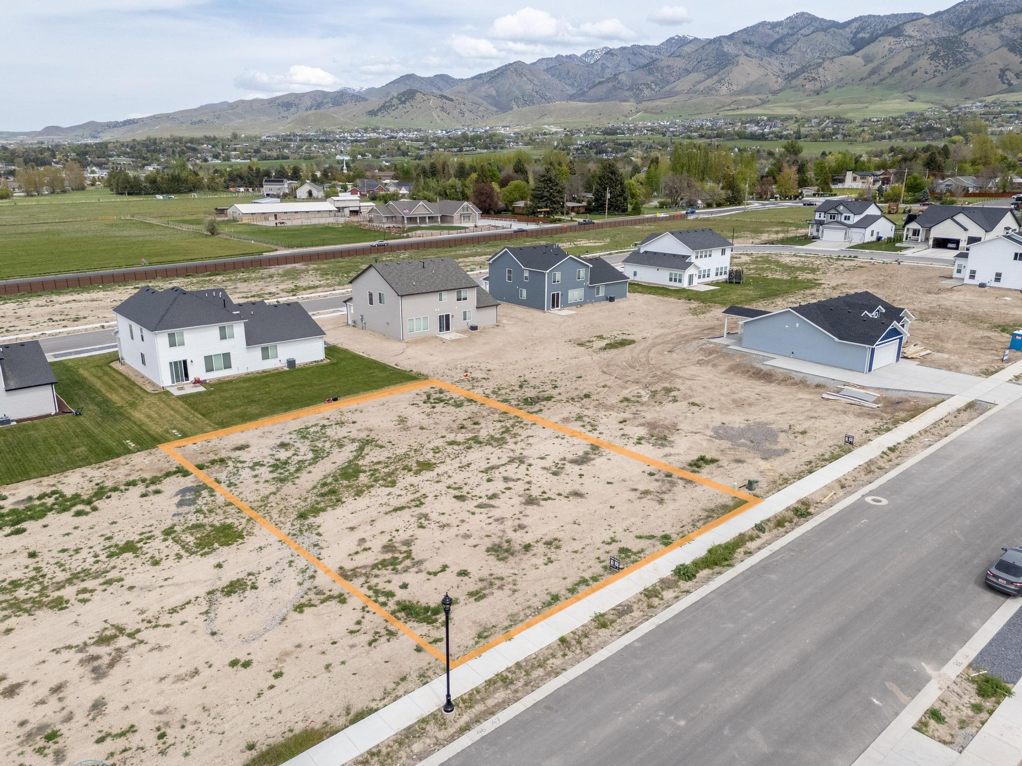 Aerial perspective of suburban area featuring a mountain backdrop and property boundaries highlighted